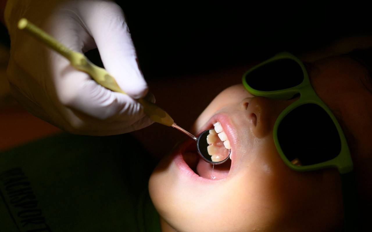 Eine Kinderzahnärztin untersucht ein dreijähriges Kind