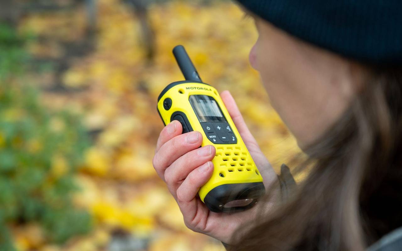 Eine Frau spricht in ein Walkie-Talkie in ihrer Hand