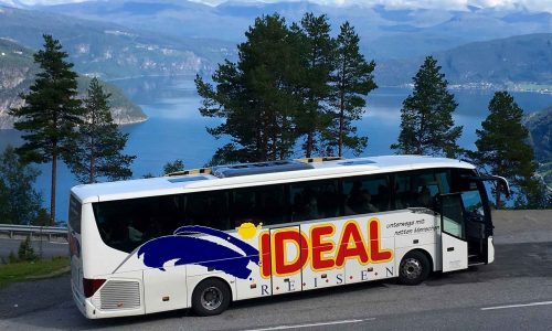 IDEAL REISEN-Bus, geparkt vor einem schönen Fjord während einer Busreise durch Skandinavien