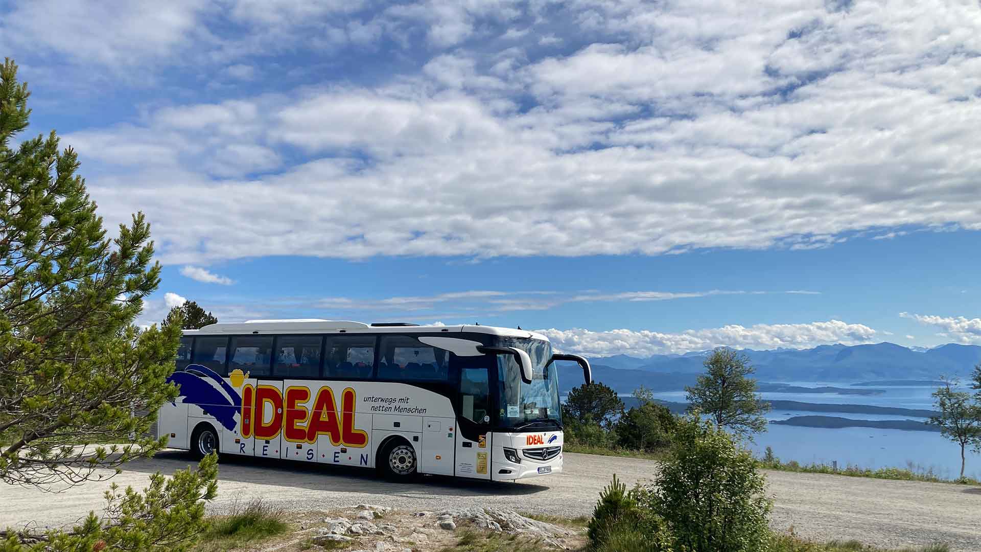 IDEAL REISEN-Bus, geparkt vor einem schönen Fjord während einer Busreise durch Skandinavien
