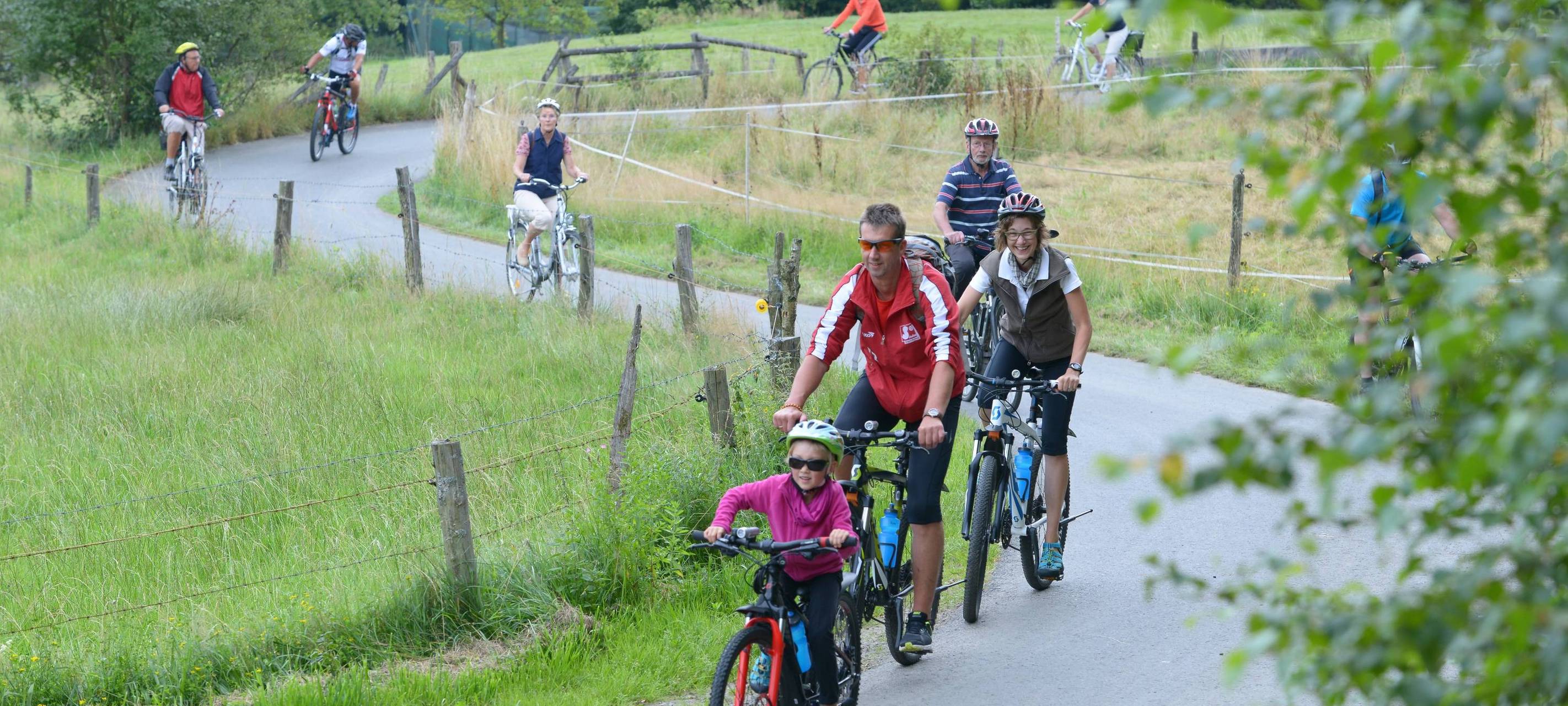 Ein Feldweg auf dem Fahrradfahrer mit ihren Fahrrädern unterwegs sind.