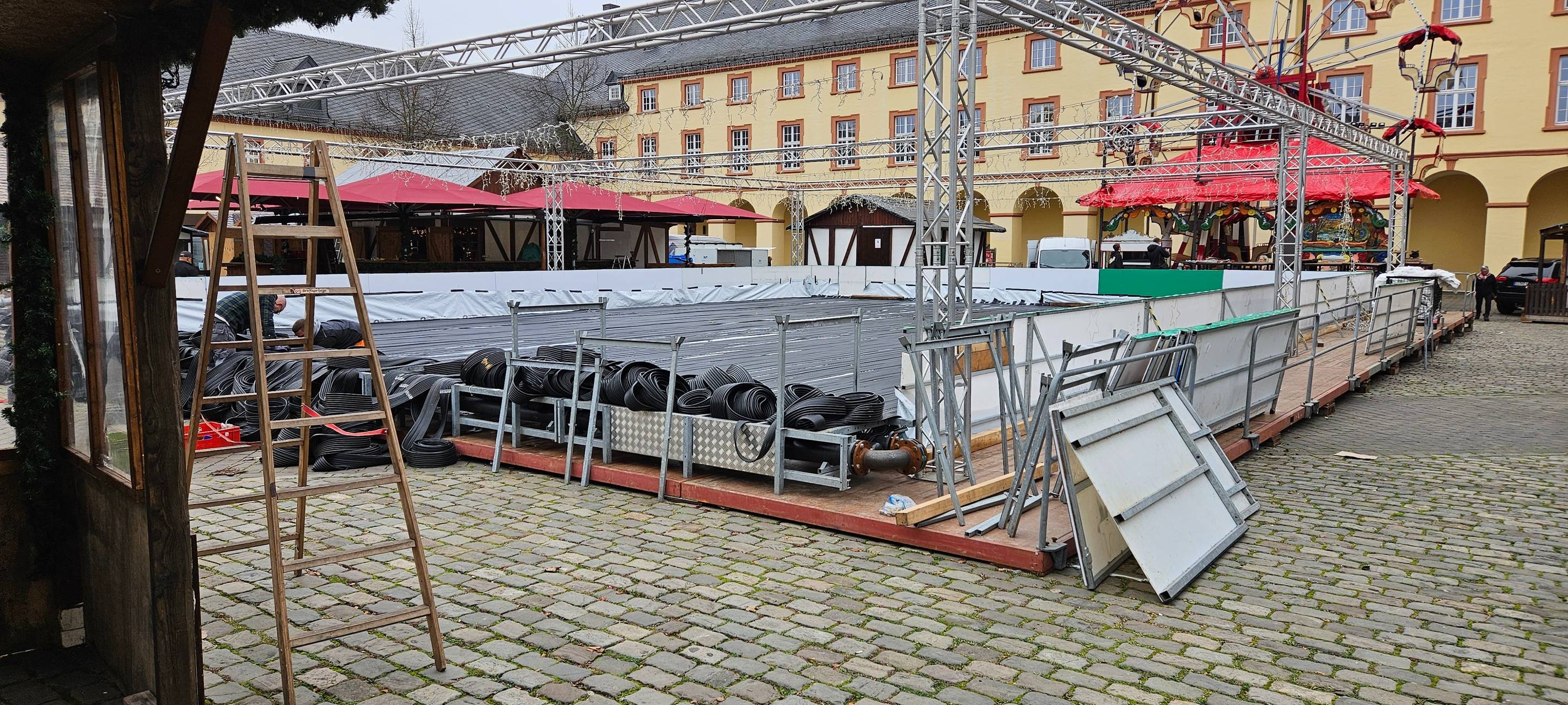 Weihnachtsmarkt Siegen Oberes Schloss Aufbau der Buden. Im Mittelpunkt wird die große Eisbahn aufgebaut.