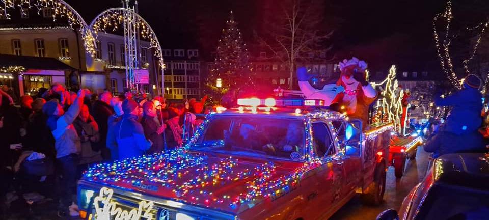 Ein amerikanischer alter Wagen mit Lichterketten und bunten Kugeln geschmückt. Drumherum stehen begeisterte Zuschauerinnen und Zuschauer!