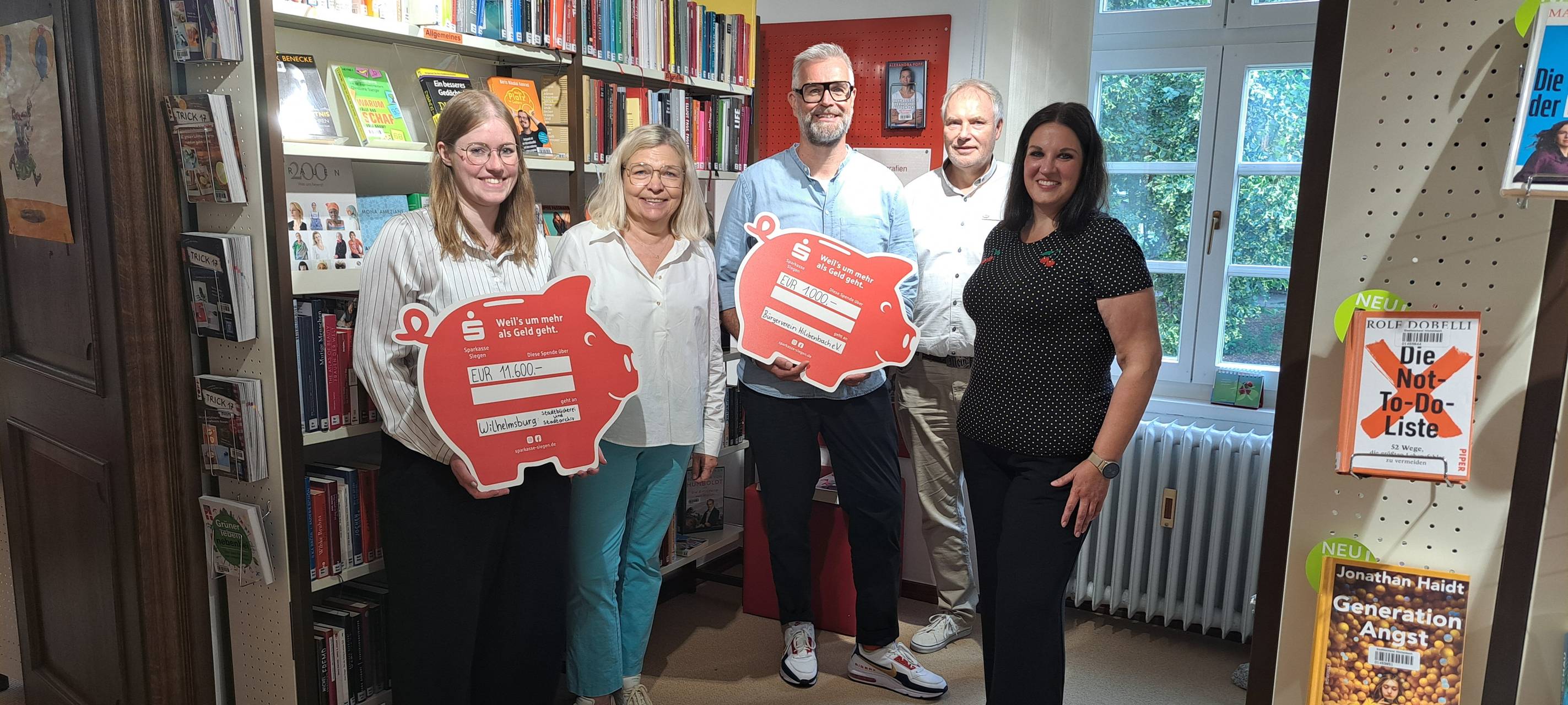 Von links: Büchereileiterin Leonie Hartmann, Tanja Herdlitschke von der Sparkasse Siegen, Thomas Klein vom Bürgerverein Hilchenbach, Hans-Jürgen Klein und Verena Hof-Freudenberg von der Stadt Hilchenbach bei der Spendenübergabe in der städtischen Bücherei.
