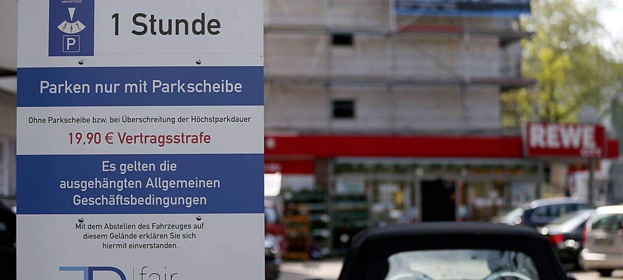 Ein Hinweisschild auf einem Parkplatz zwecks Gebühren ist zu erkennen.