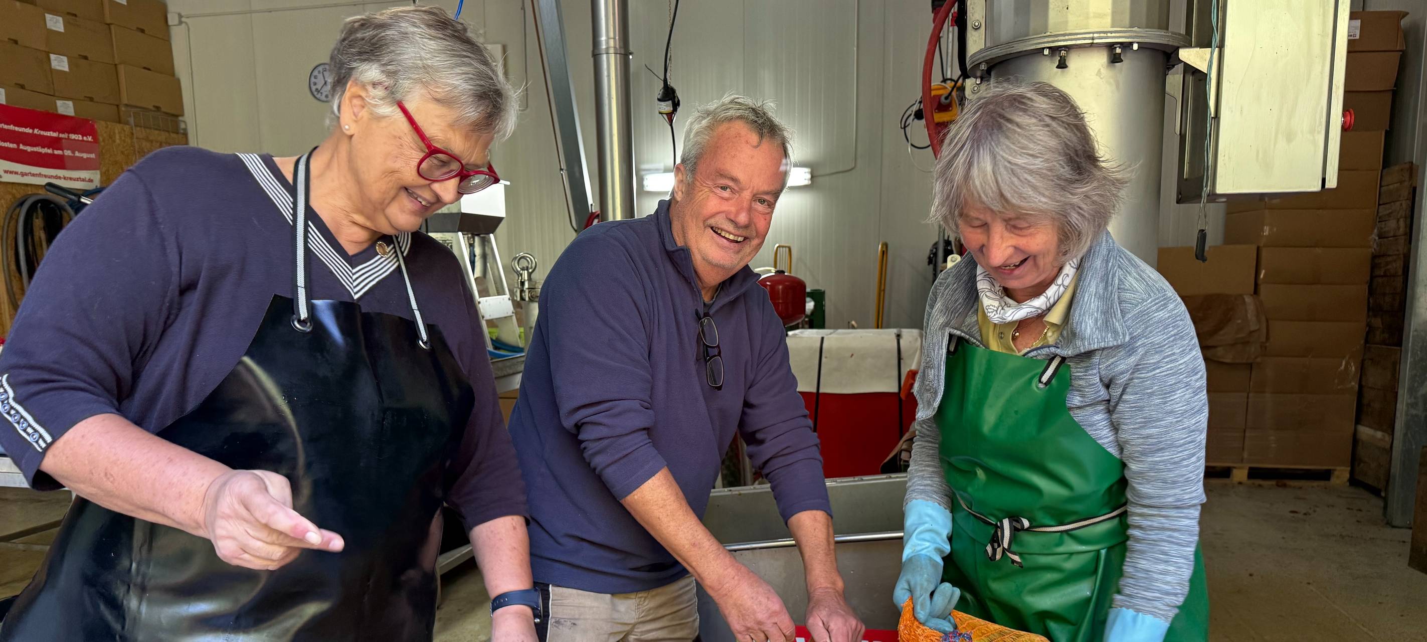 Ein Berg von Äpfeln mit vier Menschen im Hintergrund.