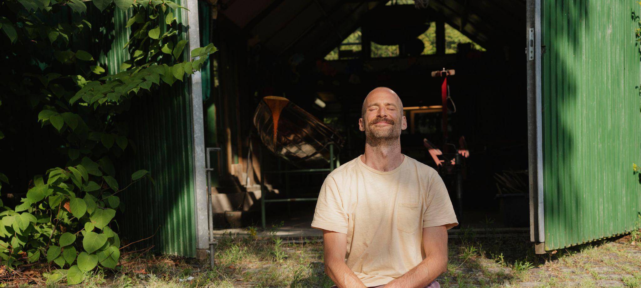 Ein Mann meditiert und genießt die Morgensonne