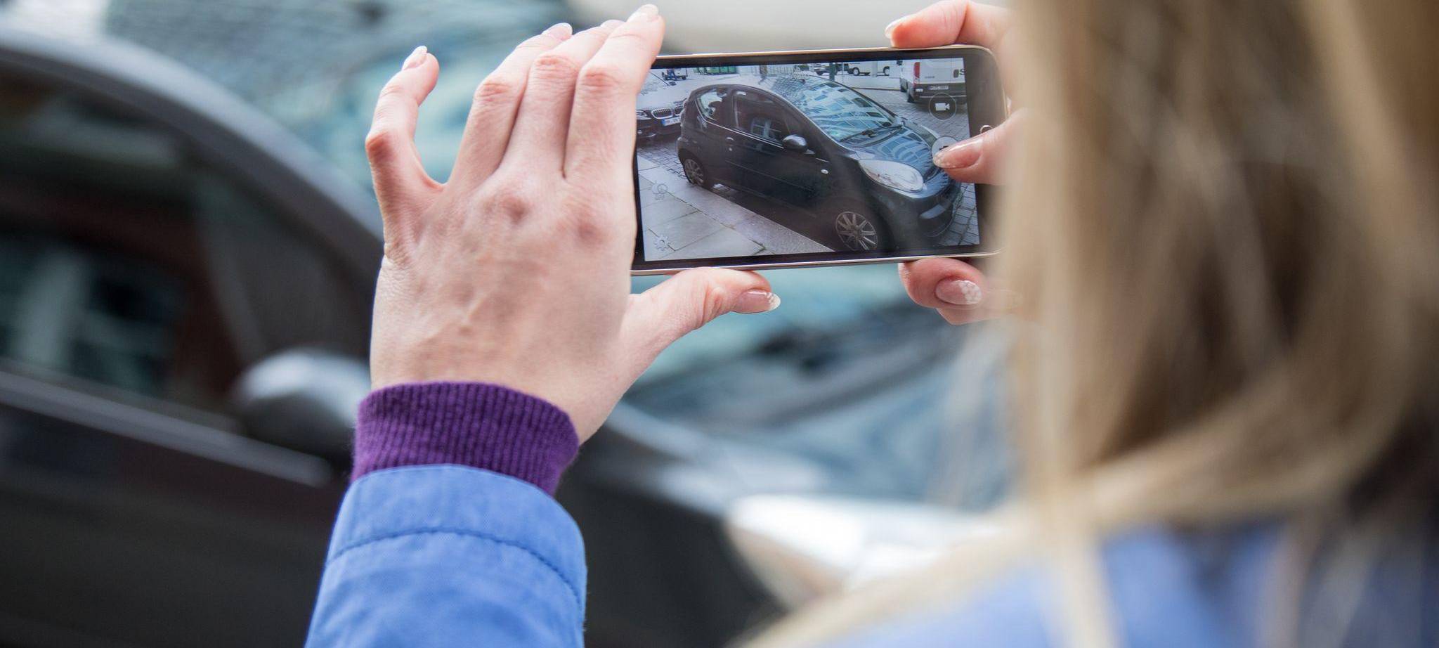 Frau fotografiert ein Auto