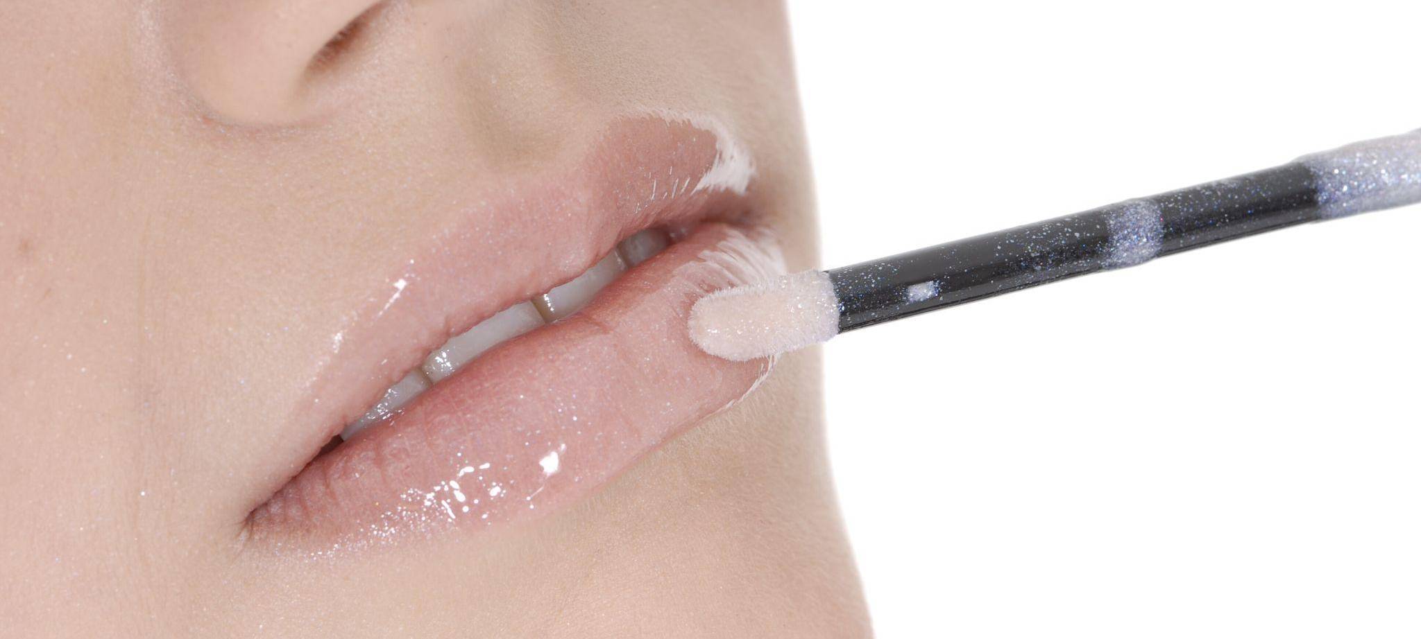 Frau schminkt die Lippen in einem Nude-Ton