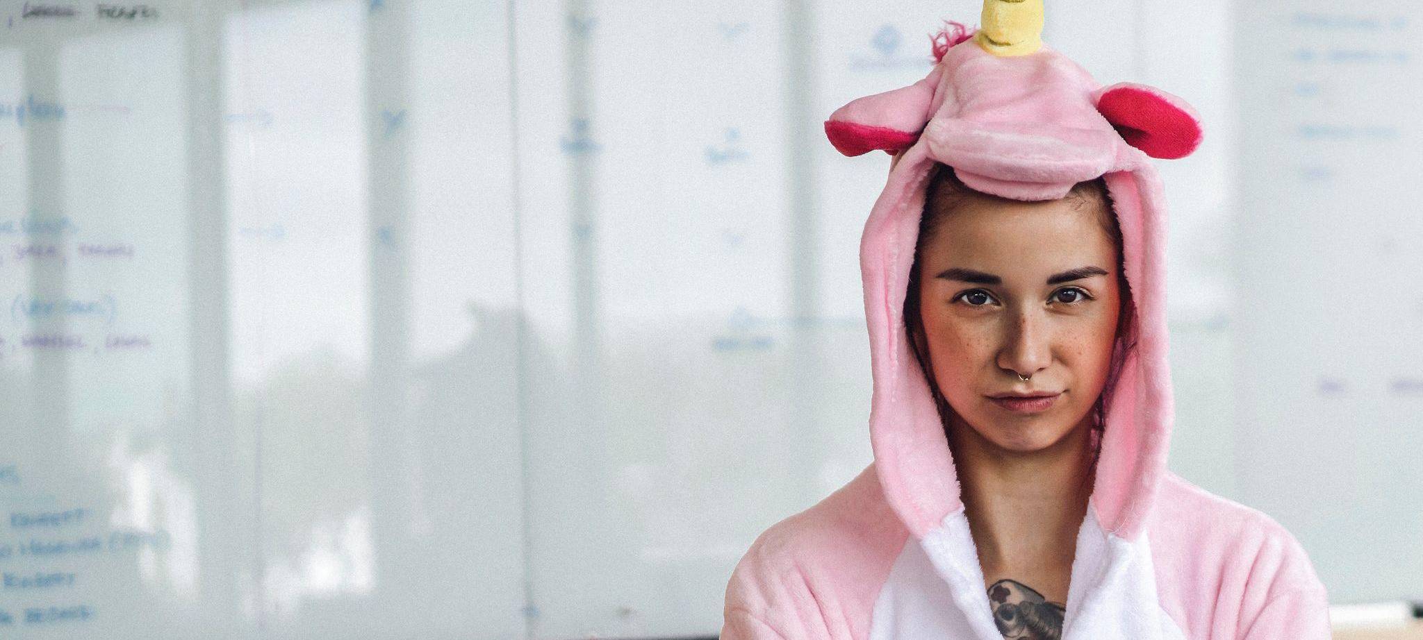Frau trägt im Büro ein Einhorn-Kostüm