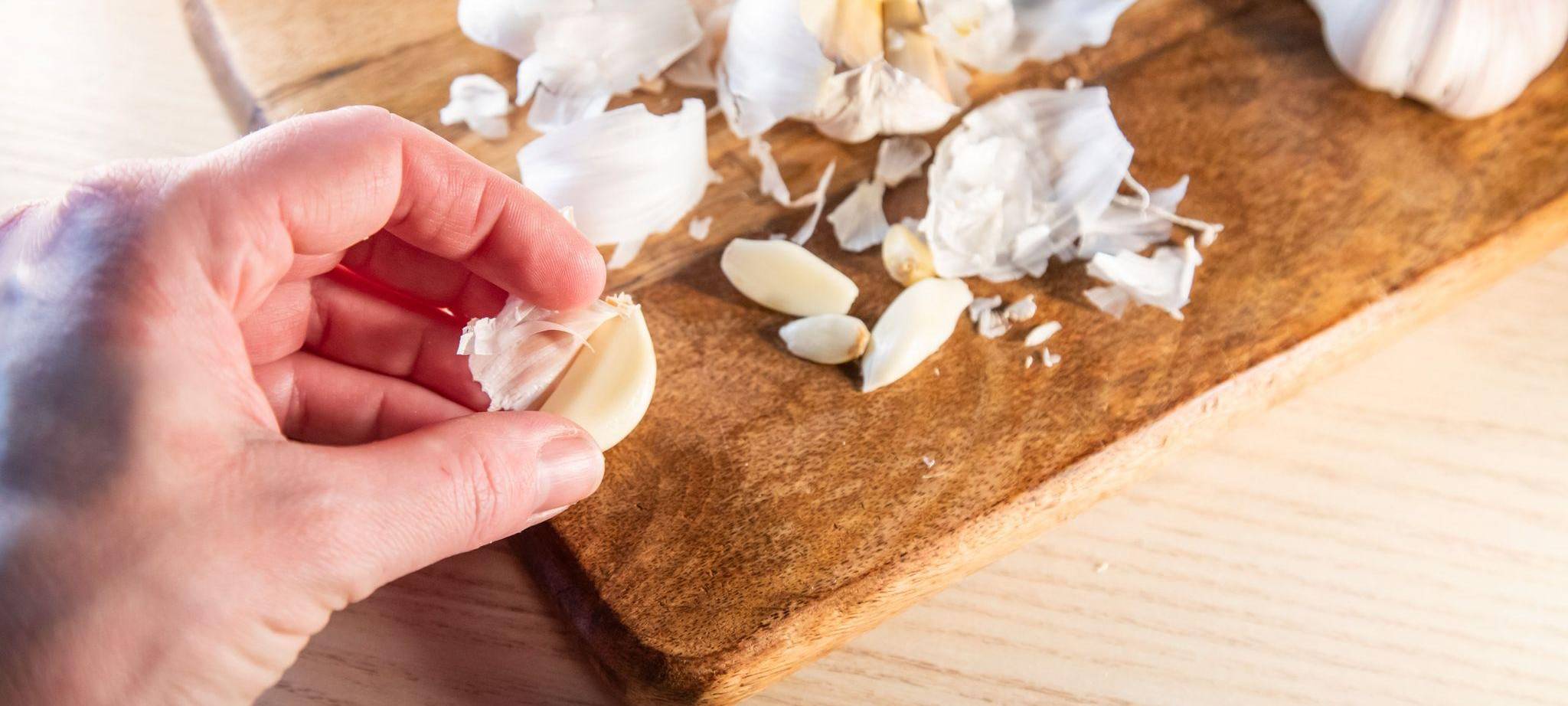 Frau pellt Knoblauchzehen