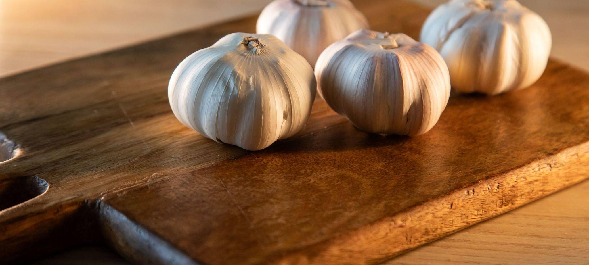 Knoblauchknollen liegen auf einem Küchentisch