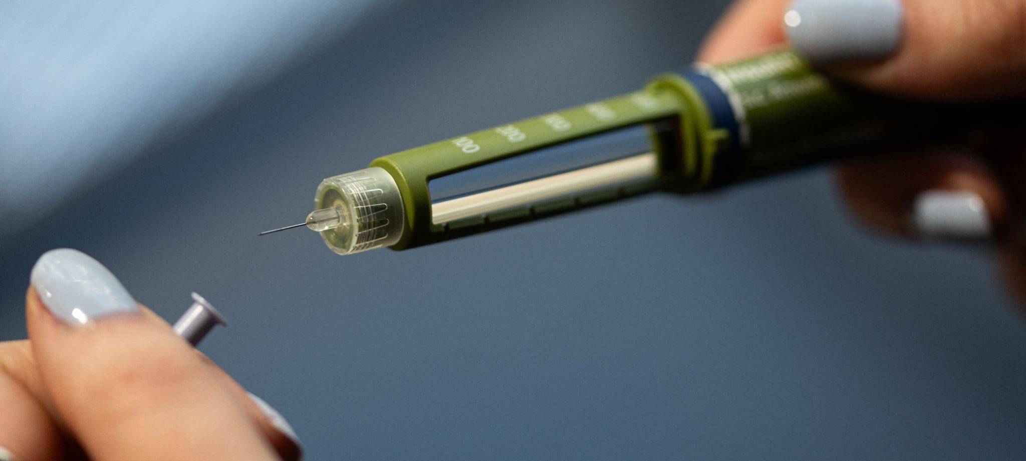 Eine Frau hält einen Insulin-Pen in der Hand