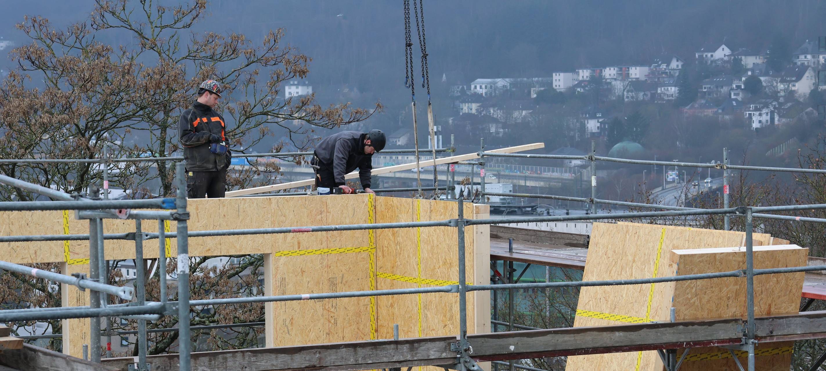 Zentimeterarbeit: Arbeiter bringen eine Wand auf dem Gebäude C an.