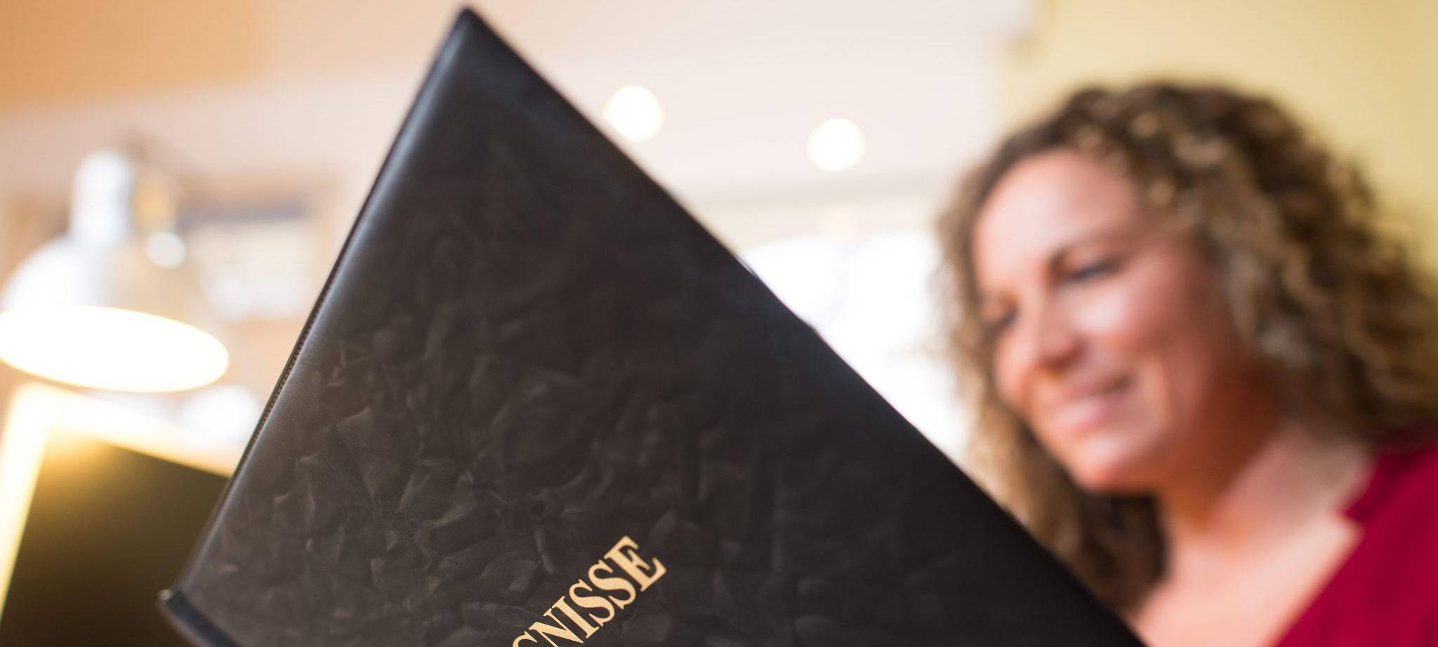 Frau liest in einer Mappe mit der Aufschrift «Zeugnisse»