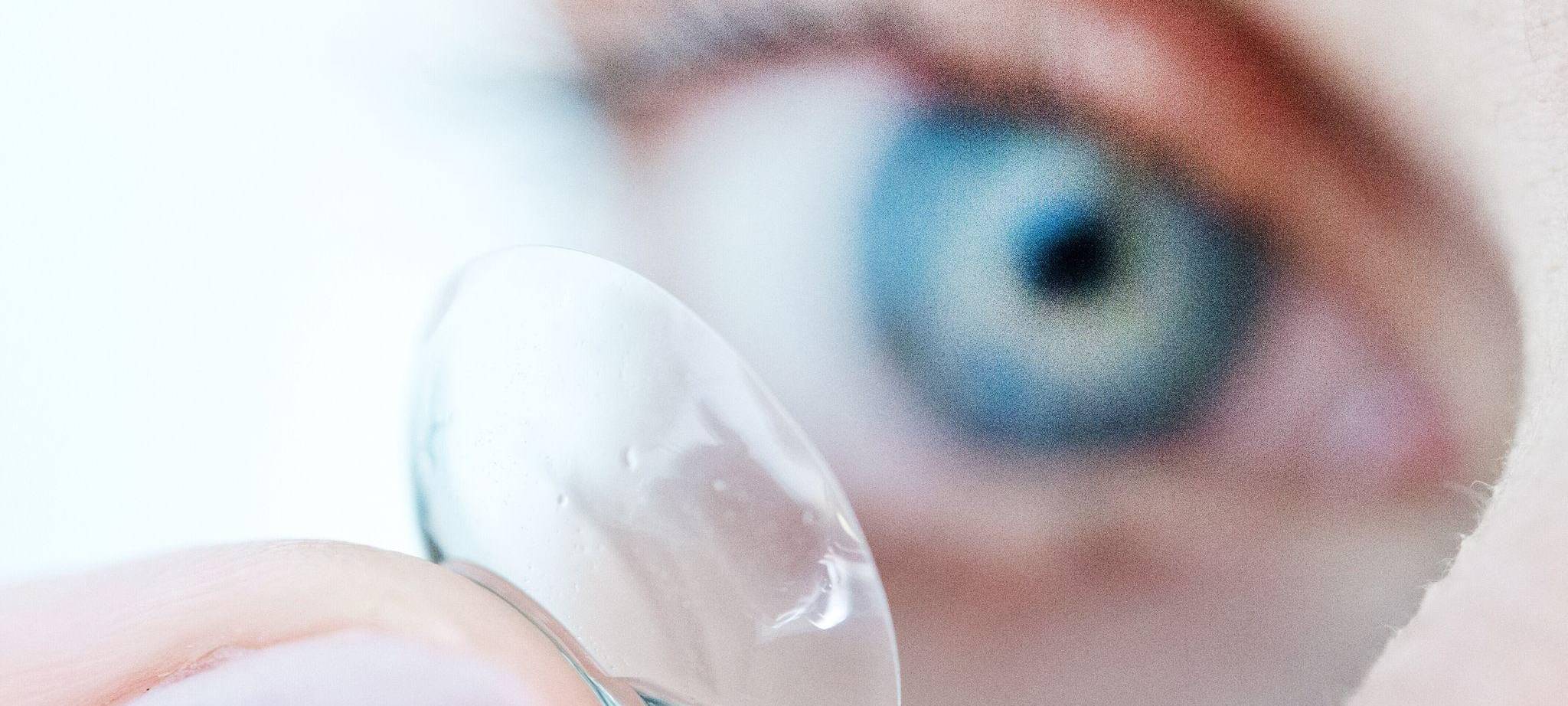 Eine Person hält eine Kontaktlinse auf dem Finger