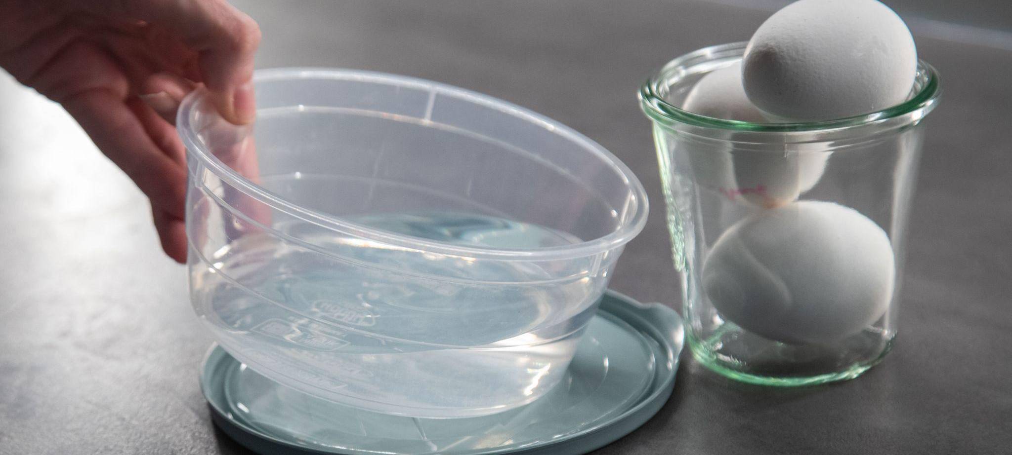 Eier liegen neben einer Schale Wasser