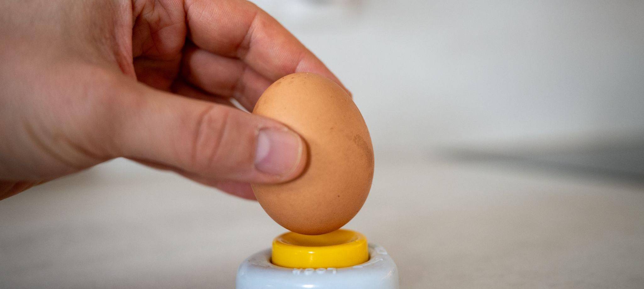 Ein Mann sticht ein Ei an