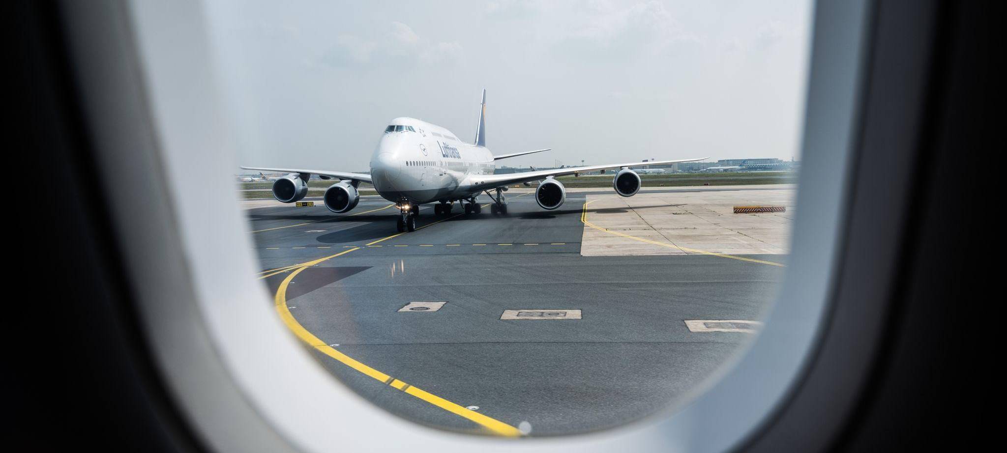 Blick aus einem Flugzeug auf die Rollbahn am Flughafen