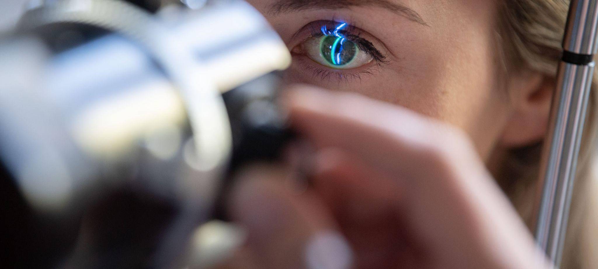 Ein Arzt untersucht das Auge einer Patientin