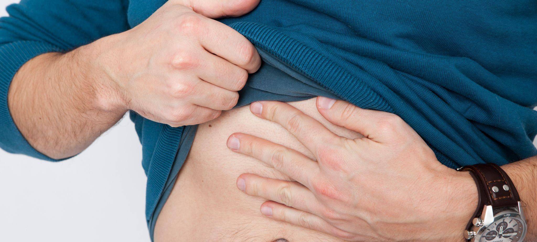Mann fasst sich an den Bauch