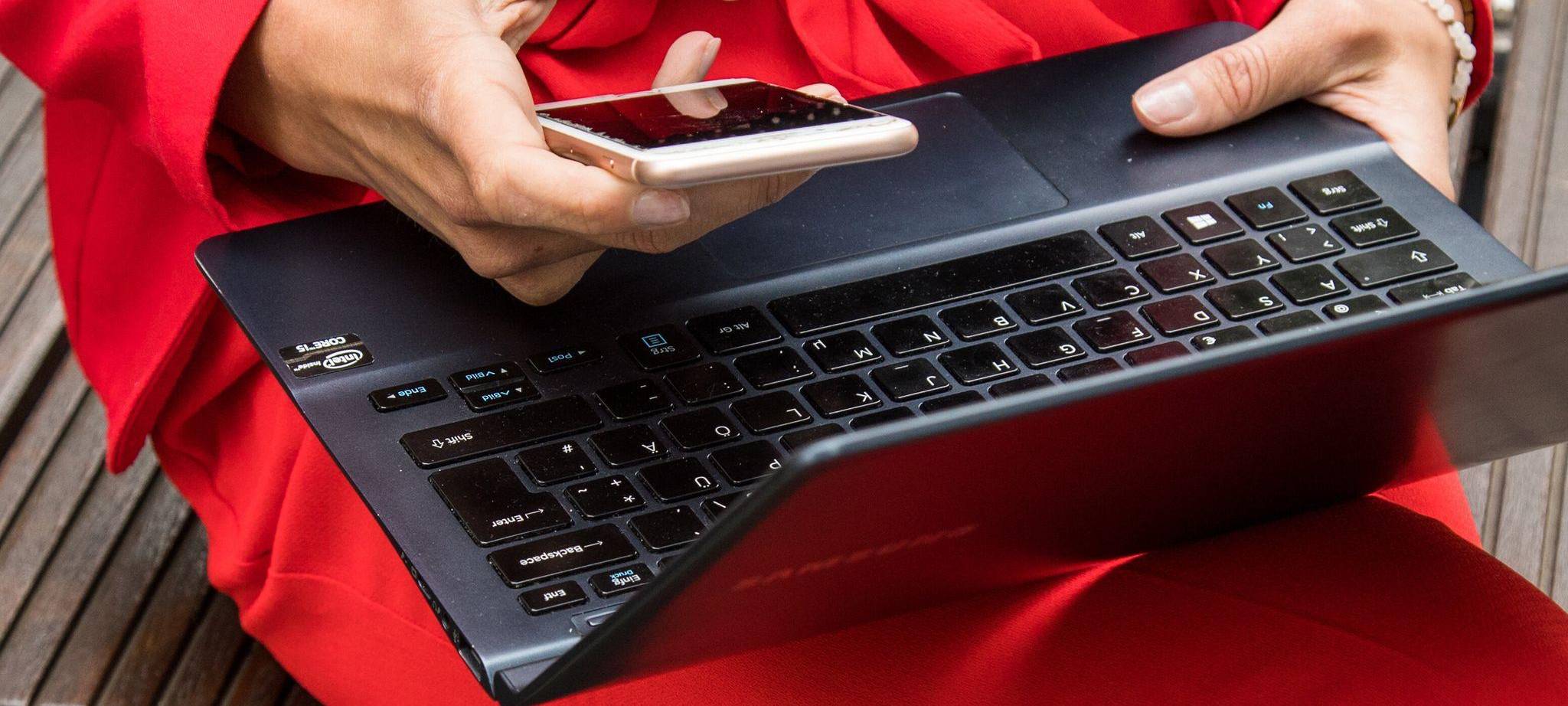 Frau mit Laptop und Smartphone