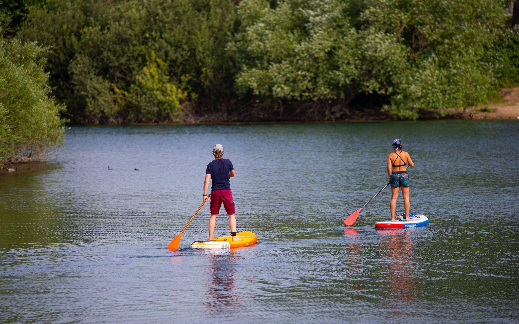 Zwei Stand-Up-Paddler gleiten über den Fühlinger See