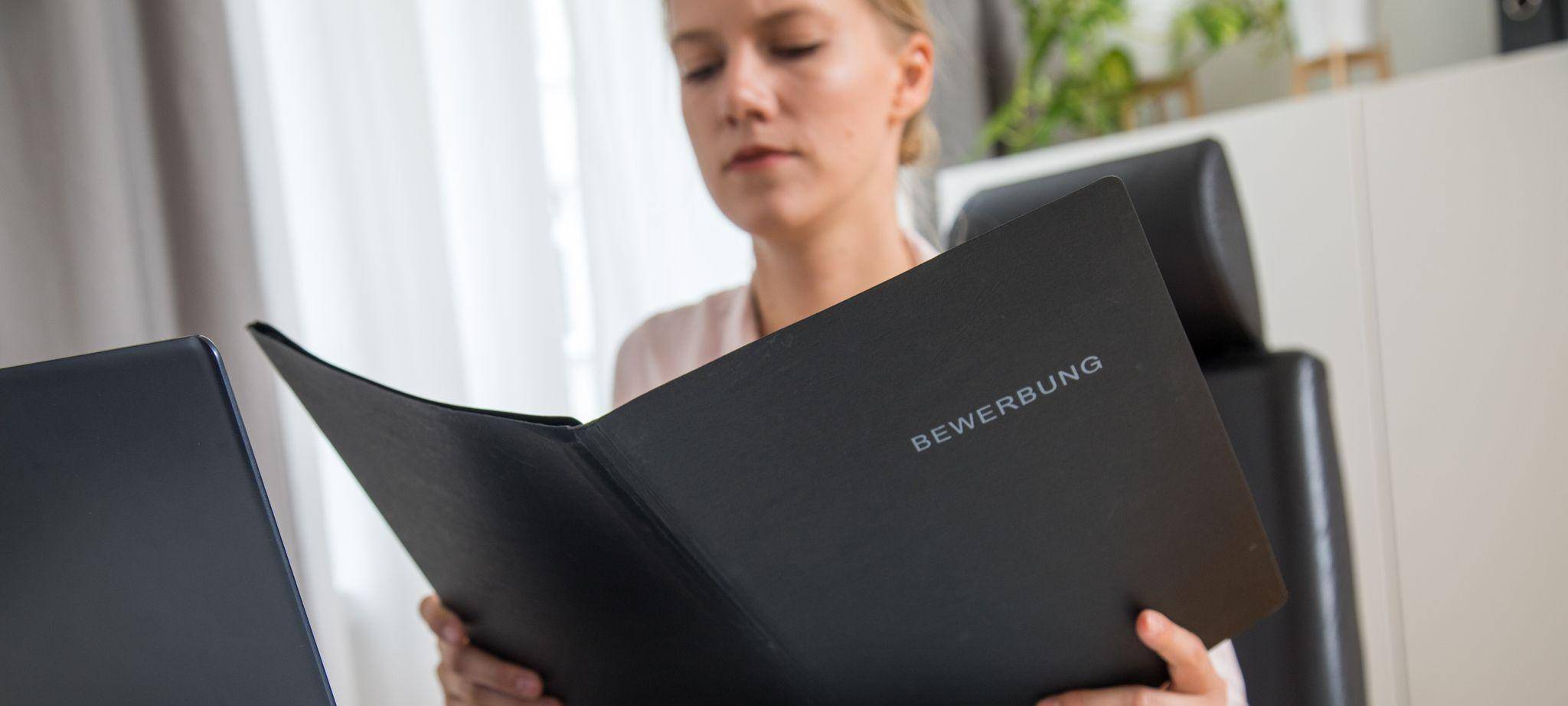 Eine Frau schaut Bewerbungsunterlagen durch
